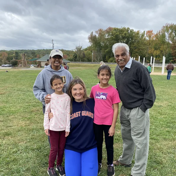 Five members of one family, from a young child to a grandfather, standing together on the camp lawn at the Family Retreat