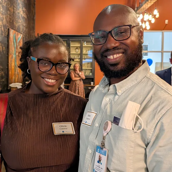 Two guests wearing name badges smiling side by side at a Party with a Purpose event