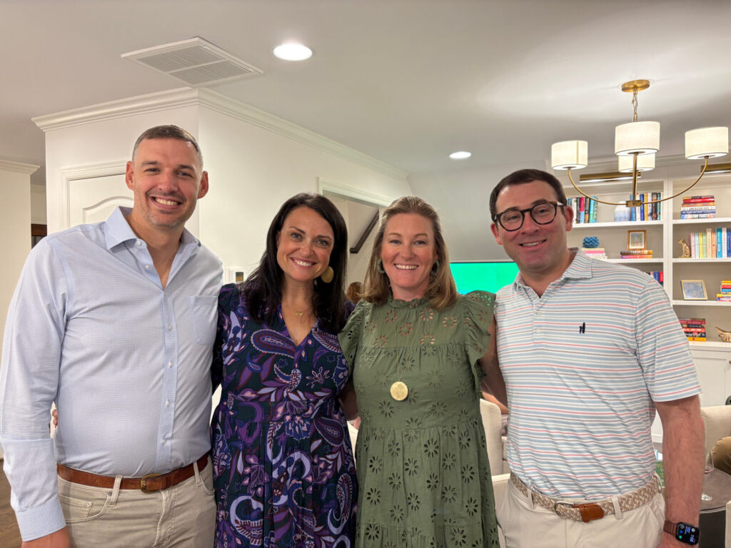 Four DFC supporters standing together at an indoor event