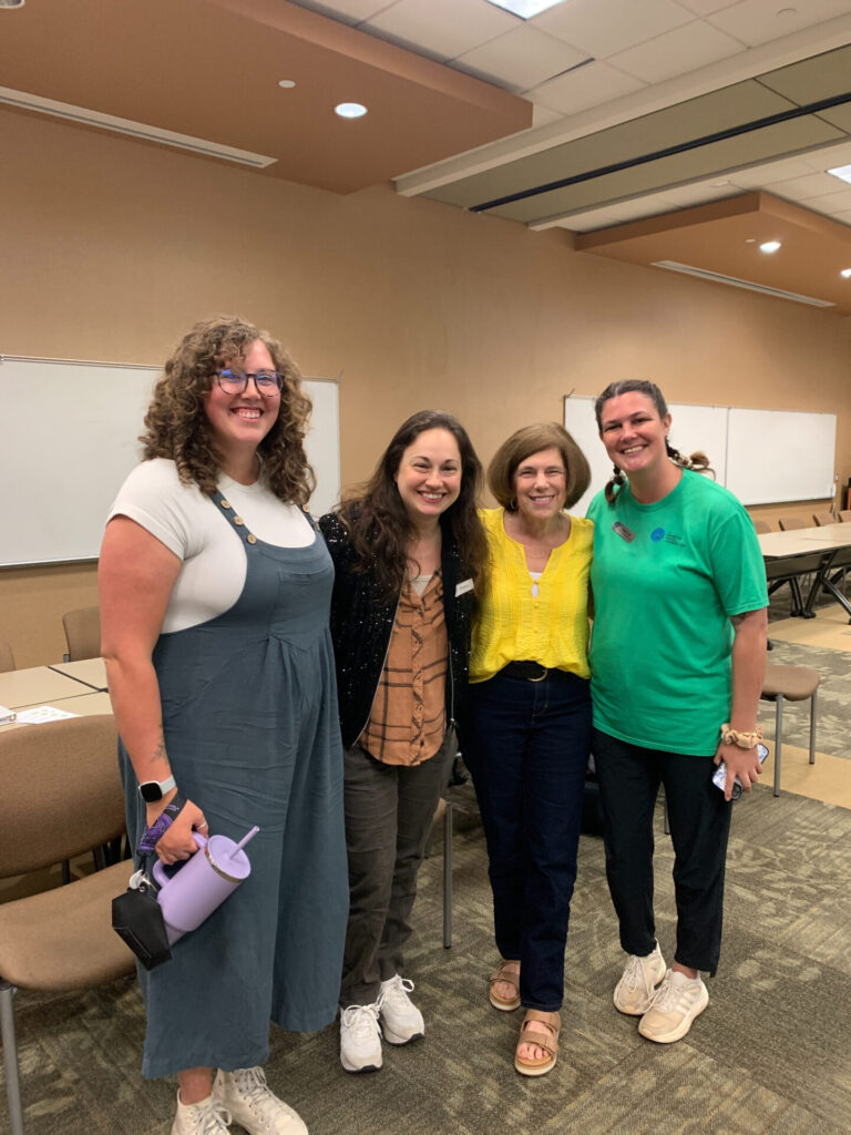 Four DFC volunteers standing together at an indoor gathering